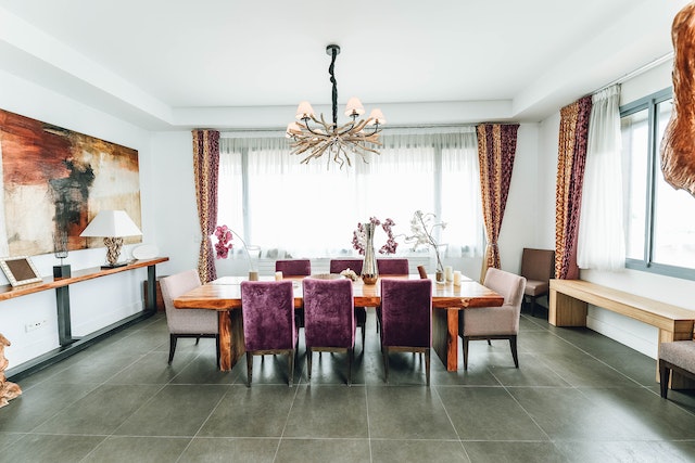 a spacious dining room with a modern rustic chandelier is lit by natural light filtered through gauzy white curtains in the centre of the room is a large square wooded table surrounded by purple and beige fabric covered chairs
